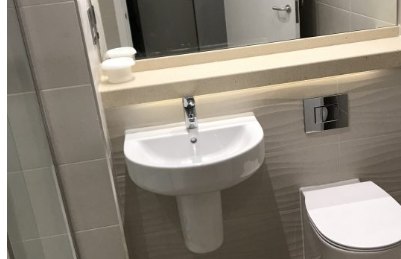 Refurbished hotel bathroom with basin and wall-hung toilet